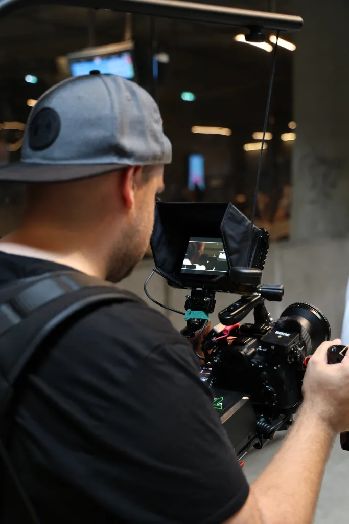 Cadreur au travail avec caméra et moniteur de contrôle pour un film corporate